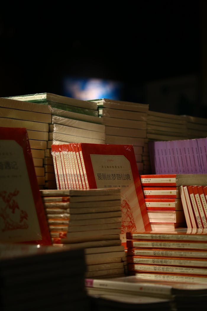 A collection of stacked books on display in a dimly lit bookstore setting.